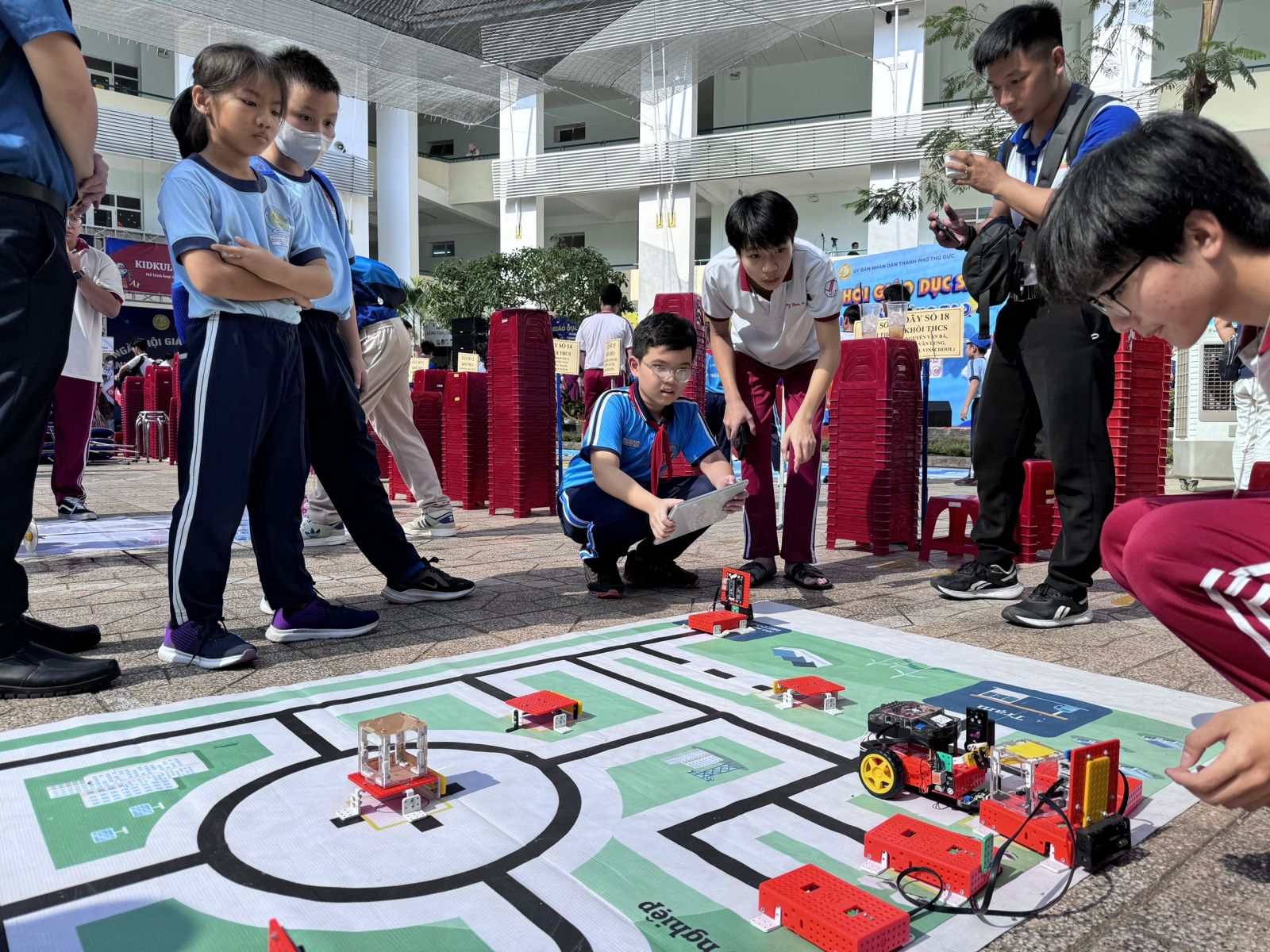 Các em học sinh điều khiển Robot bằng Máy tính bảng tại gian hàng trường Ngô Thời Nhiệm. Ảnh: Diep Nguyen